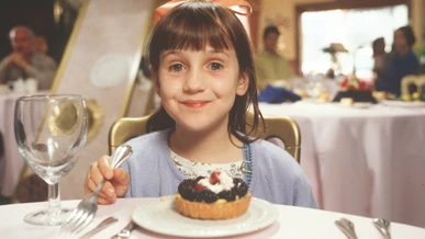Matilda Wormwood is beaming in front a yummy dessert
