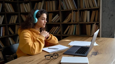A student is watching a film on her laptop in the library