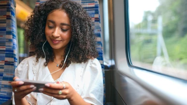 A passenger is watching a film on her mobile phone onboard a train